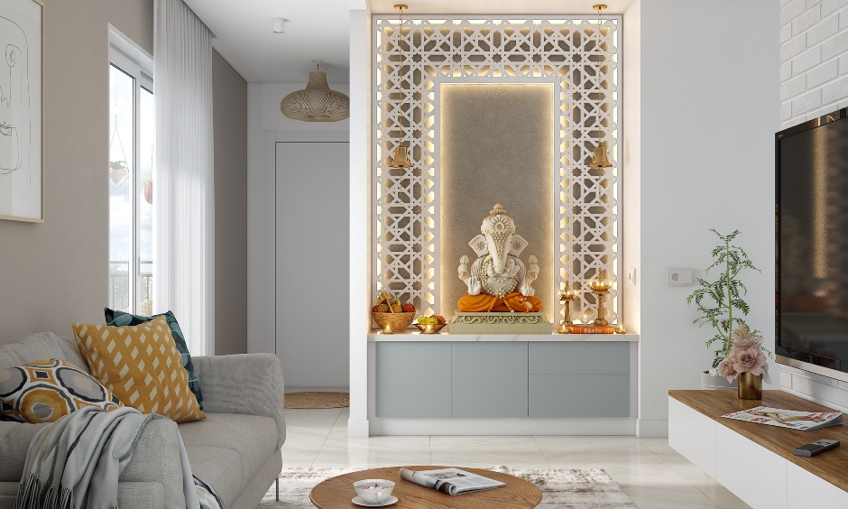 White and grey pooja unit in the living room that has a traditional jaali backdrop with backlit.